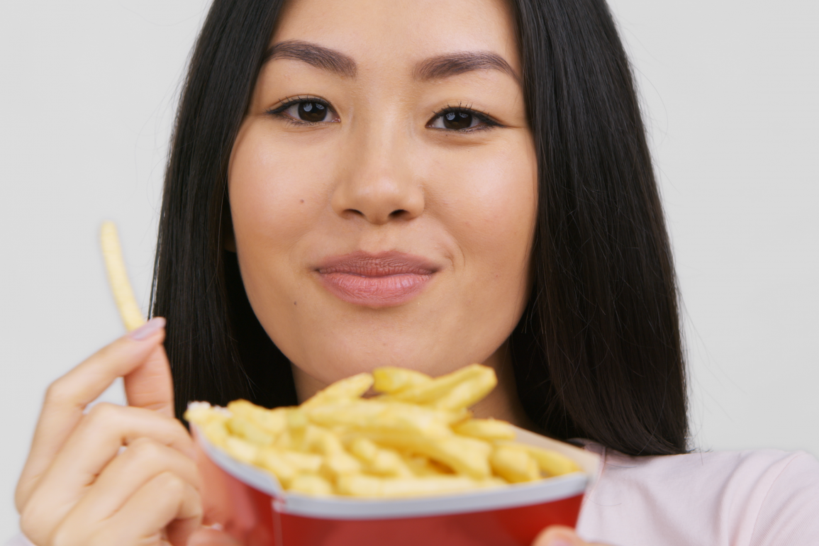 Asian woman enjoying french fries