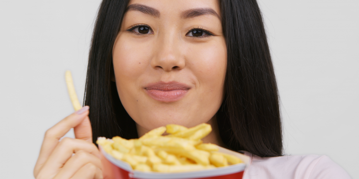 Asian woman enjoying french fries